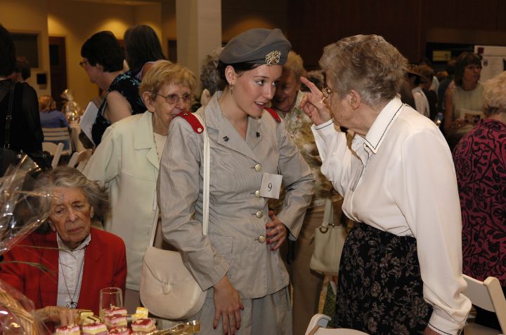 Professor Norma Jane Kolthoff, Bolton School of Nursing, CWRU, instructs a re-enactor on how to wear the Cadet Nurse uniform